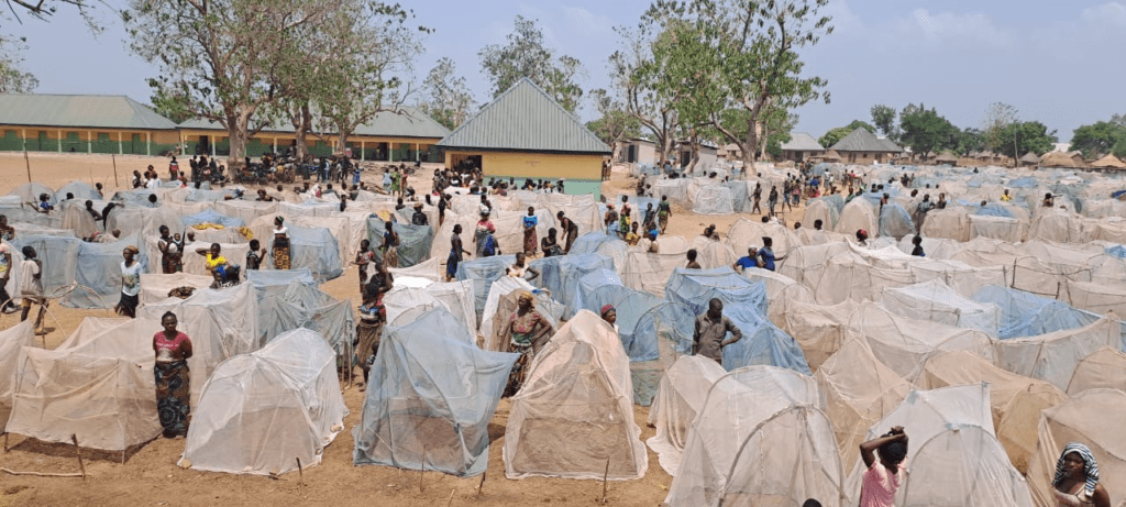 above: Temporary shelters for internally displaced people in camp near Makurdi, capital of Benue State. The state has 2 million persons forced into IDP camps because of ethnic cleansing raids described as farmer herder clashes, which are exacerbated by soaring population.  Photo by Save the Persecuted Christians. 