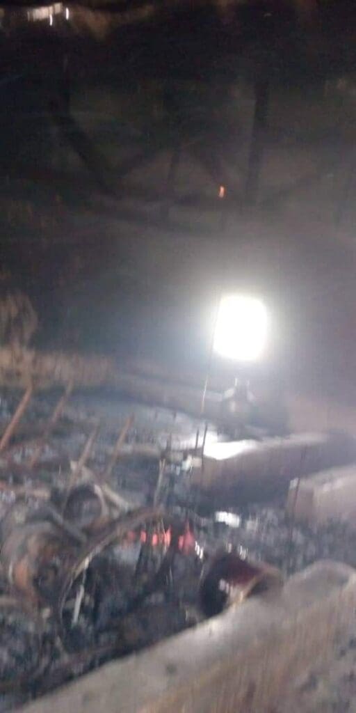 Burnt buildings in Gindin Duste from Sunday morning attacks. St Dominic Catholic Church can be seen with its humble cement row of seats with receding flames in the burnt Church (Credit: Facebook)