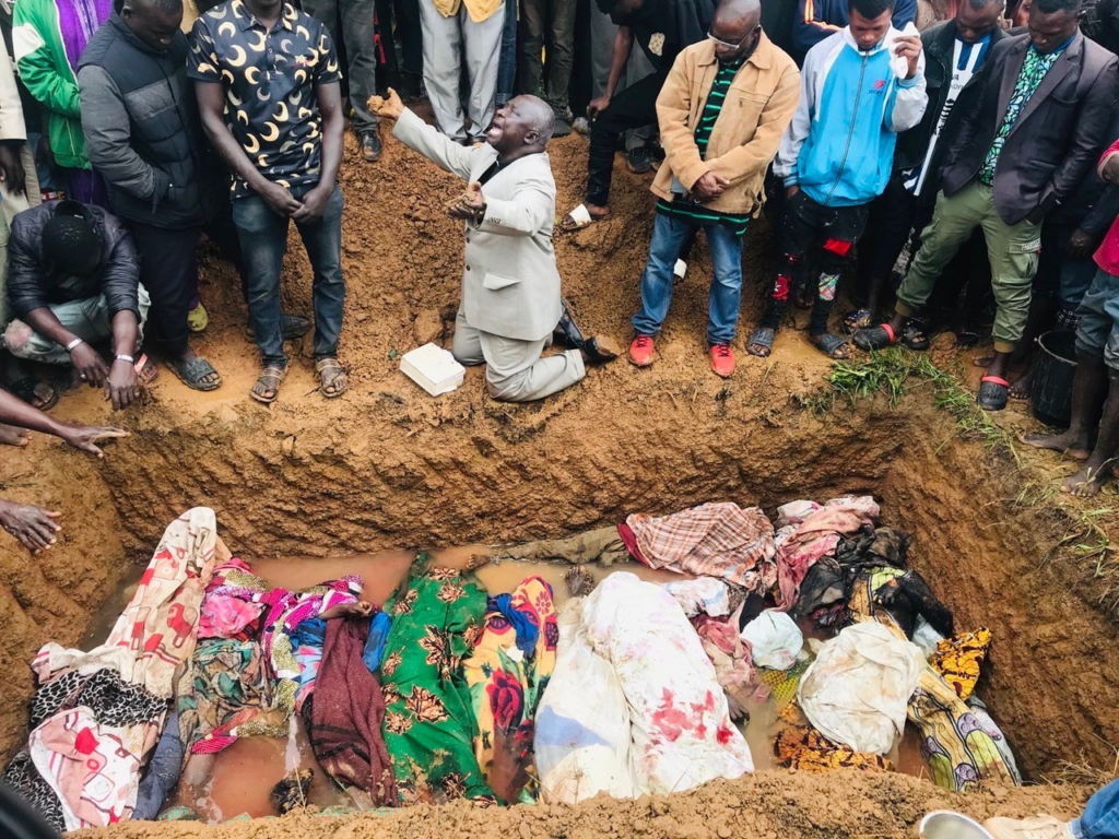 Rev. Peter Dachomo cries to Heaven at a burial ceremony in Barkin Ladi Local Governance Area, Plateau State, in August, 2023 after a massacre took the lives of 23 members of his congregation. Both Christian and Muslim families inter their departed members within 24 hours of passing. Heavy rains soaked the earth the day before, preventing the grave diggers to obtain the usual depth. Credit: Masara Kim for TruthNIgeria.