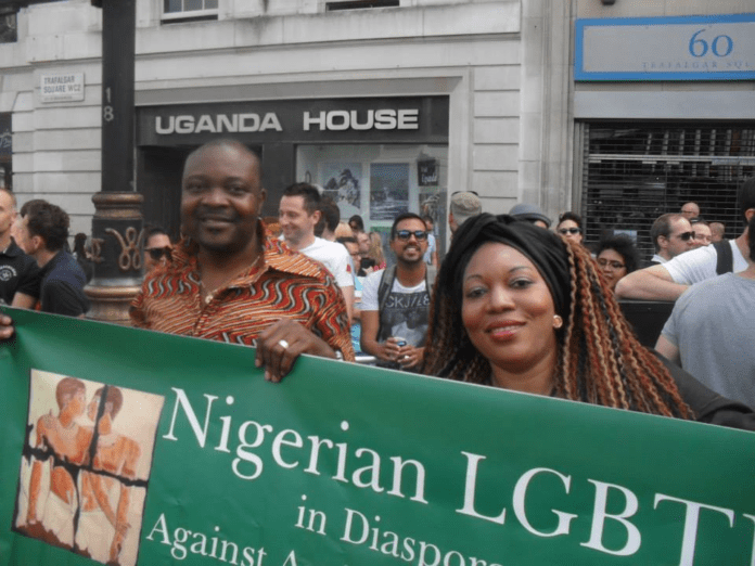 Nigerian gay rights activist Davis Mac-Iyalla (left) holding a banner at London’s 2013 Pride Parade protesting anti gay rights laws. Courtesy: Davis Mac-Iyalla https://theworld.org/stories/2014/01/14/new-anti-gay-law-nigeria-cracks-down-even-further-lgbts-0