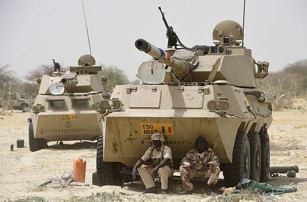 Soldiers in the Chadian military rest in the shade of an armored canon near the shore of Lake Chad on its eastern perimeter. Credit: Chadian Military.