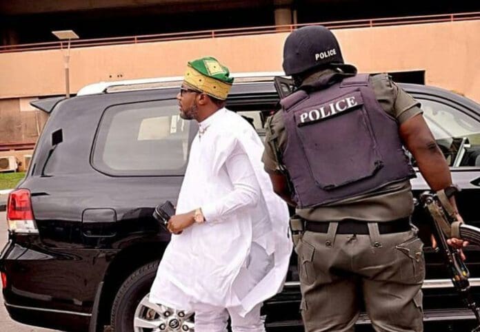 Nigerian businessman E-Money with his police escort opening his car door. Credit: E-Money/Instagram.