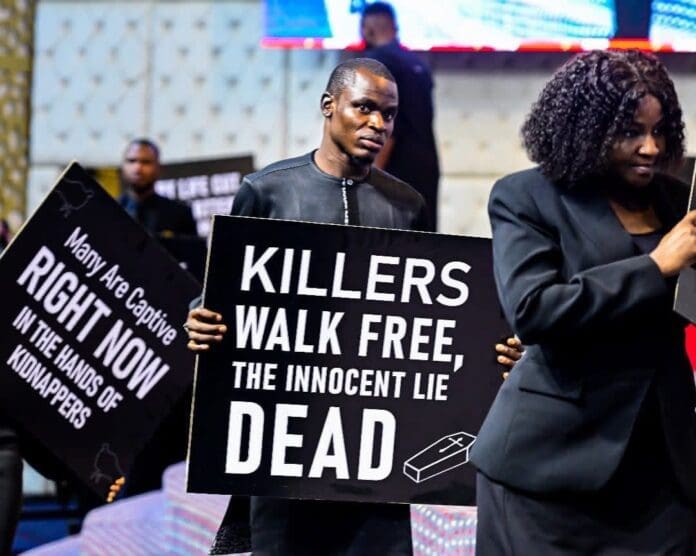 Members of Family Worship Centre holding placards in church. Credit: Sarah Omakwu|Facebook.