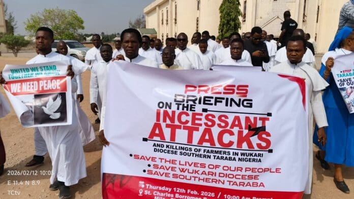 Catholic Priests holding placards during protest. Photo by Mike Odeh James.