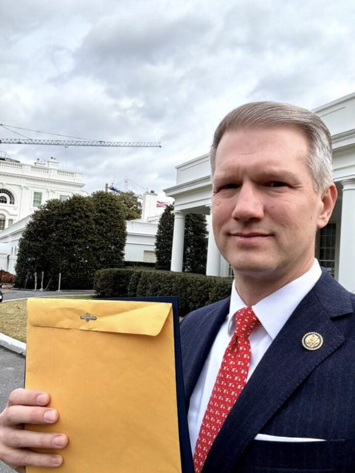 U.S. Lawmaker Riley Moore holding the 2-page congressional report| Credit: Riley Moore_X