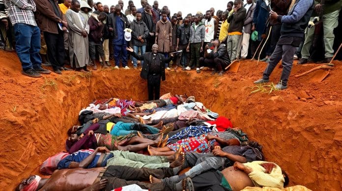 Human rights activist Pastor Ezekiel Dachomo cries out to heavens standing in front of 21 victims of June 22 attack laid in a mass grave in Kawel village, Mushere district, in Bokkos LGA Plateau State. Photo by by Masara Kim/TruthNigeria.